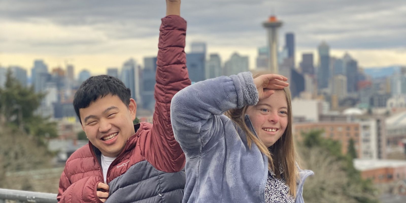 Two Tavon members posing in front of the Seattle skyline